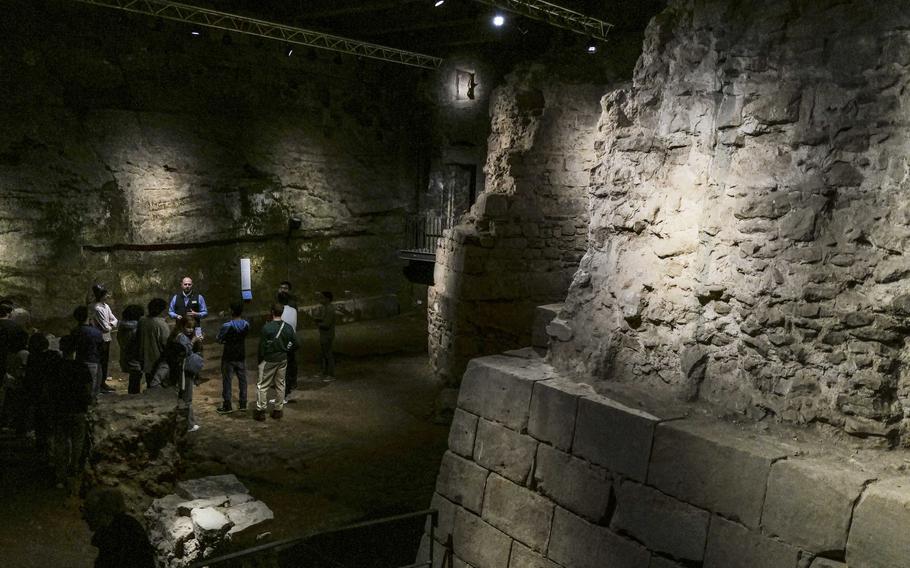 A guide leads a student tour group to the site of the old ball court and adjacent dungeon at the Saar Historical Museum in Saarbruecken, Germany, on Oct. 19, 2023. The ball court allowed castle residents to play early forms of tennis and racquetball.