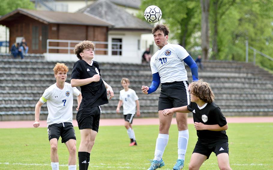 Brussels center back Antonio Pranjic rises up to head a corner between Baumholder's Trevor Cheney, left, and Gabe Dubay, right, during a May 4, 2024, match at Minick Field in Baumholder, Germany.