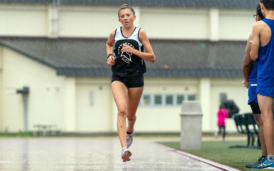 Running through a heavy morning downpour, Zama’s Liliana Fennessey crosses the finish line first during Saturday’s DODEA-Japan cross country race at Misawa Air Base. Fennessey was timed in 20 minutes, 38.2 seconds and the Trojans tied Yokota for top spot in the team standings.