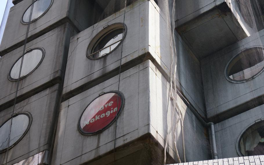 Netting covers the iconic Nakagin Capsule Tower in Tokyo's Ginza district, Tuesday, April 12, 2022.