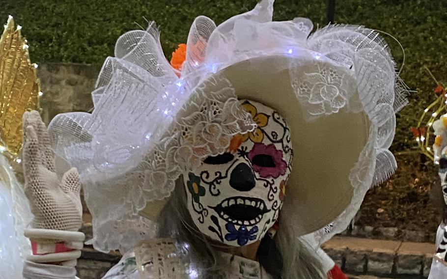 A woman in costume celebrates the Day of the Dead, or Dia de los Muertos, in the Spiritlandia River Parade in San Antonio, Texas. 