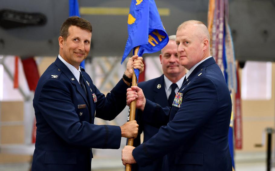 During the 104th Fighter Wing change of command ceremony, Col. David Halasi-Kun, left, hands the flag to Lt. Col. Steve Reynolds on June 12, 2022, at Barnes National Air Guard Base in Westfield, Mass.