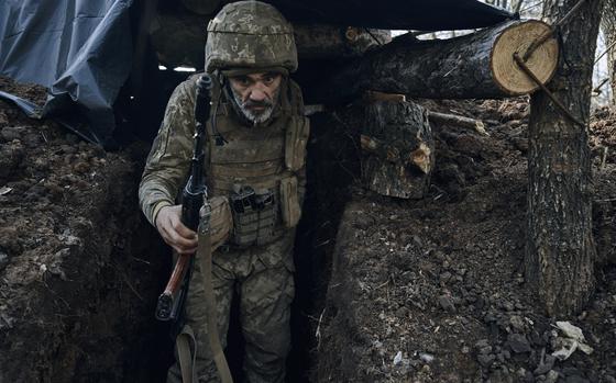 A Ukrainian soldier of the 28th brigade leaves a shelter on the frontline during a battle with Russian troops near Bakhmut, Donetsk region, Ukraine, Friday, March 24, 2023. (AP Photo/Libkos)