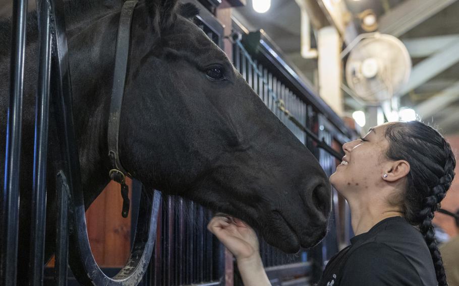 Silva smiles and scratches her horse.