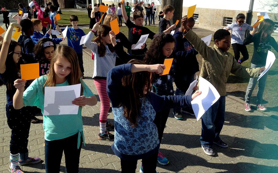Fourth graders at Boeblingen Elementary and Middle School in Stuttgart, Germany, position sheets of paper to capture the reflection of the sun being eclipsed by the moon in 2015. A recent Government Accountability Office report singles out DODEA students in fourth and eighth grades for their excellent performances on a national assessment of math and reading over the past decade.