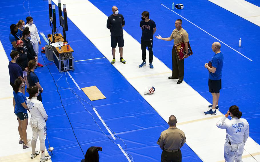 The commander of Marine Corps Air Station Iwakuni, Col. Lance Lewis, presents a gift to the U.S. women’s Olympic fencing team at Lotus Culture Center Area, part of the Atago Sports Complex, in Iwakuni, Japan, July 14, 2021. 