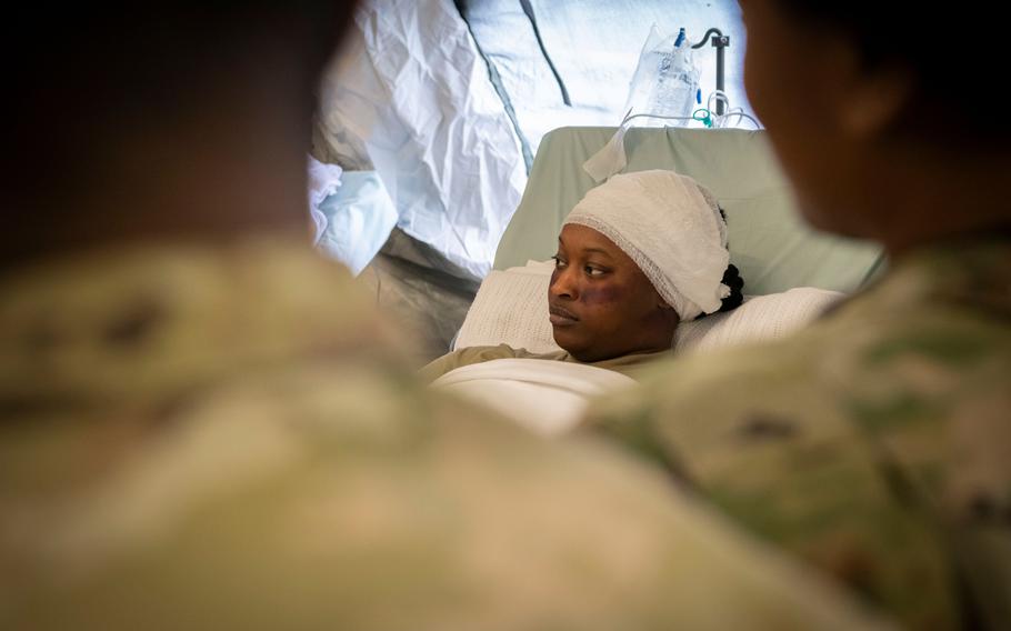 Spc. Ny-Kendra Mattox acts as an injured 14-year-old girl during a hospital exercise at Baumholder Army Airfield, Germany, on May 17, 2024. For the exercise, some 200 reserve soldiers deployed to Germany to build a field hospital from Army pre-positioned stock, which had never been done in Europe before.