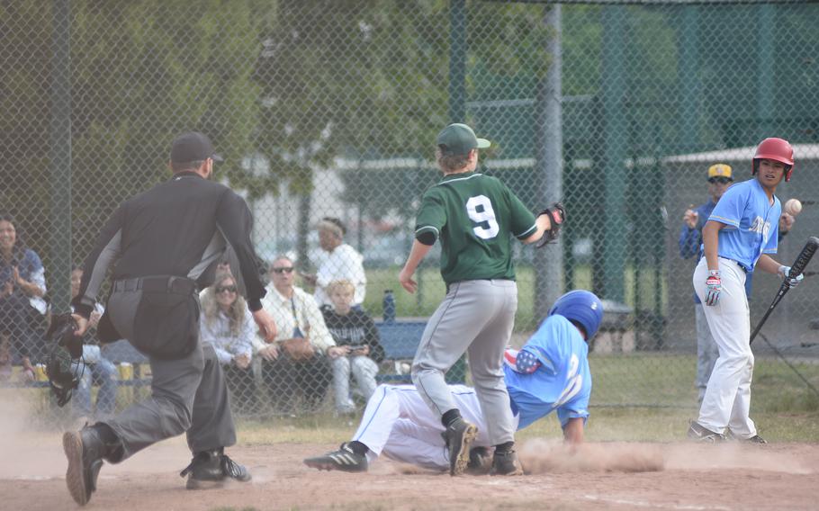 Sigonella's Henry Hirst slides into home as Alconbury's Andrew Barbee waits for the throw Wednesday, May 21, 2025, on the opening day of the DODEA-Europe Division II/III baseball championships at Ramstein Air Base, Germany.