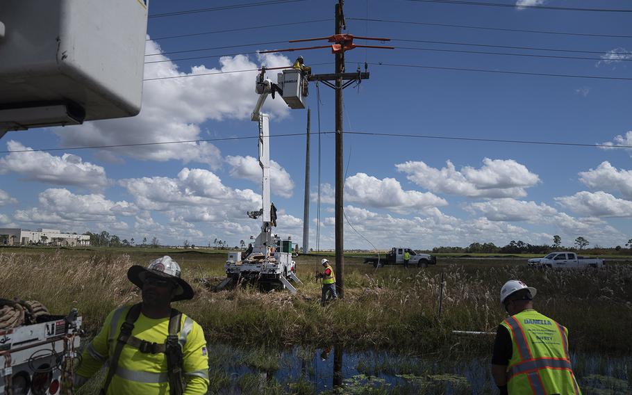 Utility workers fix aboveground power lines along Florida State Highway 31 outside Babcock Ranch. 