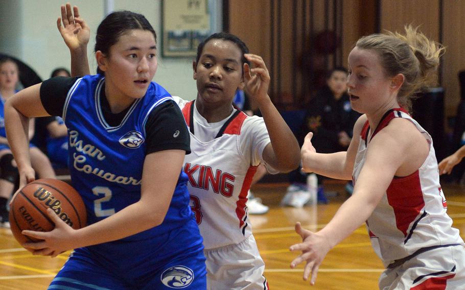 Osan's Hanna Rutland looks to pass against E.J. King's Moa Best and Madylyn O'Neill during Monday's Far East Girls Division II pool-play game, won by the Cobras 61-37