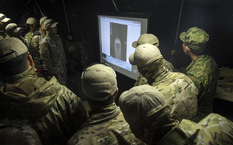 Members of a South Korean navy dive team examine an X-ray image of a possible underwater mine during a Foal Eagle drill in Jinhae, South Korea, March 6, 2017.