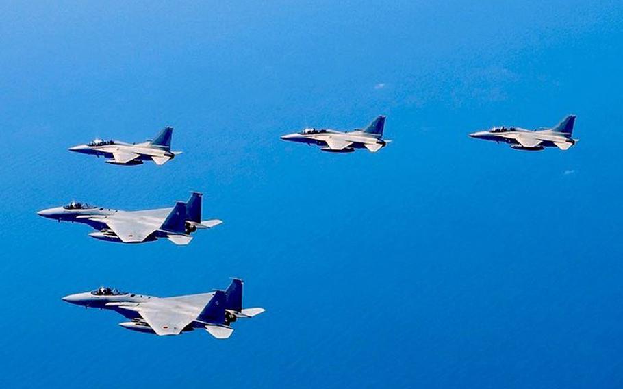Japanese F-15J Eagle fighters fly in formation with Philippine Air Force FA-50s in this photo tweeted by the Japan Air Self-Defense Force, Wednesday, Dec. 7, 2022.
