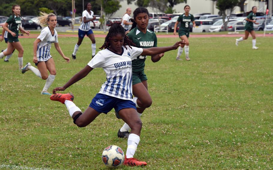 Two of the girls D-I championship match goal scorers, Guam High's NyKale Penn boots the ball in front of Kubasaki's Solares Solano.