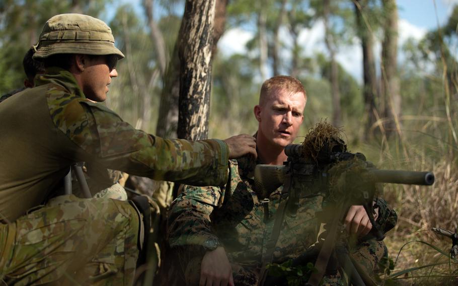 An Australian soldier shows a U.S. Marine a semi-automatic sniper system during the Southern Jackaroo exercise at Shoalwater Bay Training Area in Queensland, Australia, May 17, 2022. 