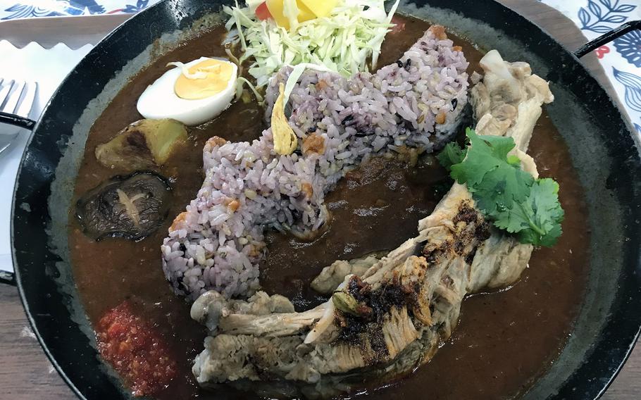 Curry Savila serves up a plate of Yanbaru curry, complete with a large pork spare rib, for 1,080 yen. 