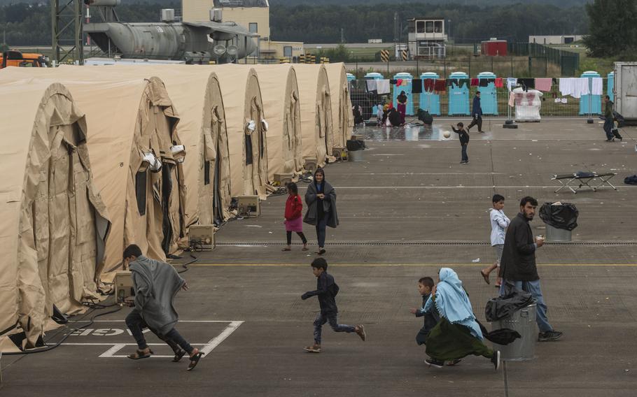 Children run towards tents. 