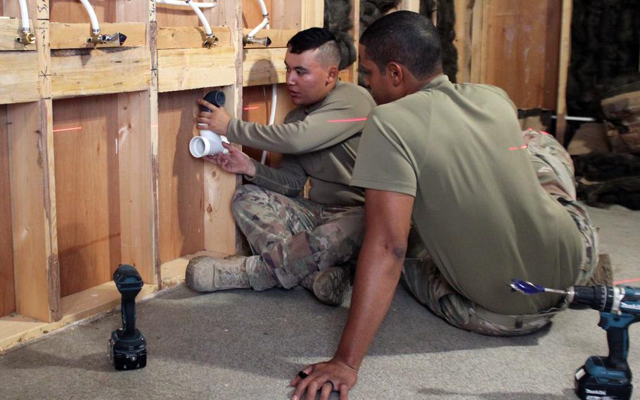 Senior Airmen Jamie Villagomez and Giancarlos Perez, plumbers with the 380th Expeditionary Civil Engineer Squadron, plan out placements of pipes on a renovation project at Al Dhafra Air Base, United Arab Emirates, in December 2021. 