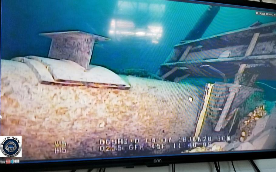 A television screen shows underwater video footage of a pipeline.