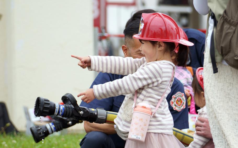 A youngster tries out a fire hose during Spring Festival at Naval Air Facility Atsugi, Japan, April 22, 2023.