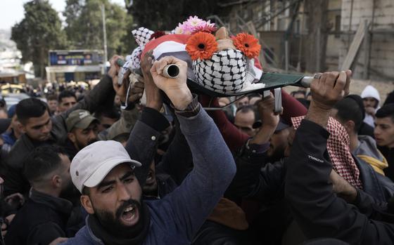 Palestinian mourners carry the body of Ahmad Kahla, 45, during his funeral in the West Bank village of Rammun, Sunday, Jan. 15, 2023. The Palestinian Health Ministry says Israeli troops have shot and killed the Palestinian man in the occupied West Bank. The Israeli military said troops opened fire when a passenger in a suspicious vehicle tried to grab a soldier's weapon. (AP Photo/Majdi Mohammed)