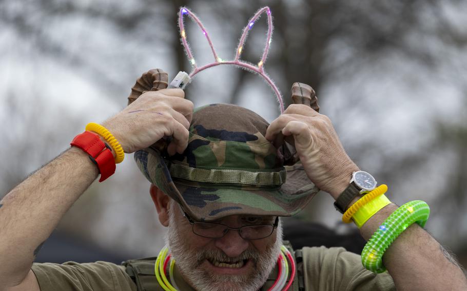 A man adjusts a light-up bunny ears on his head