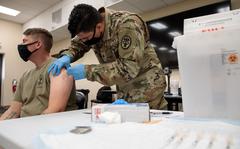 Army Cpl. Jonathan Leon Camacho, a practical nursing specialist with Dwight D. Eisenhower Army Medical Center at Fort Gordon, Ga, injects an Army Reserve Soldier from the 447th Military Police Company with the COVID-19 vaccination, Aug 21, 2021, at Camp Shelby Joint Forces Training Center (CSJFTC), Miss. The mobilized soldiers based out of North Canton, Ohio, are at CSJFTC training for an upcoming deployment.(Arizona Army National Guard photo by Sgt. 1st Class Brian A. Barbour)