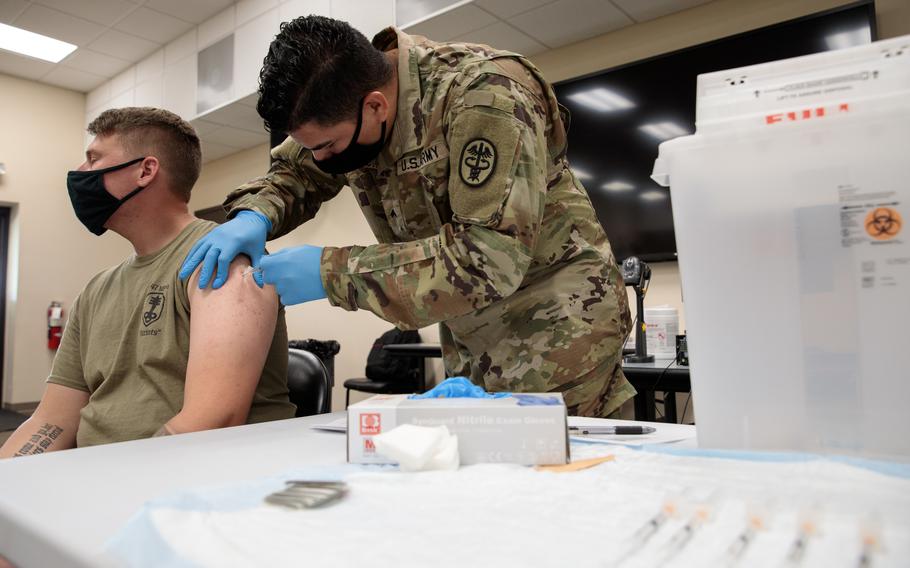 Army Cpl. Jonathan Leon Camacho, a practical nursing specialist with Dwight D. Eisenhower Army Medical Center at Fort Gordon, Ga, injects an Army Reserve Soldier from the 447th Military Police Company with the COVID-19 vaccination, Aug 21, 2021, at Camp Shelby Joint Forces Training Center (CSJFTC), Miss. 