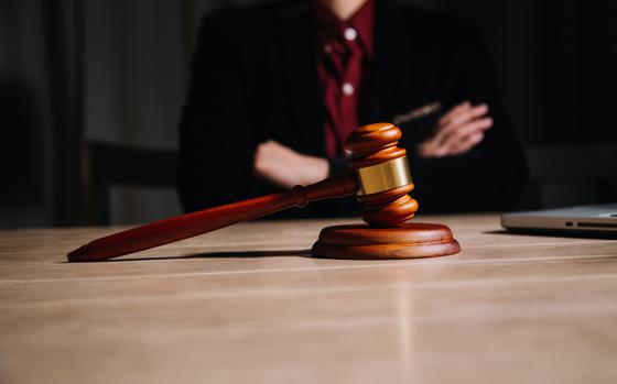 Judge torso, arms crossed with a gavel in front of them
