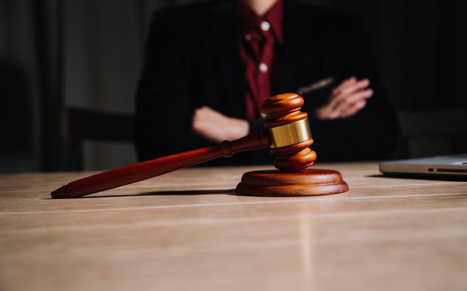 Judge torso, arms crossed with a gavel in front of them