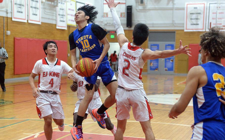 Yokota's Royce Canta goes up for a shot against E.J. King's Nolan FitzGerald during Friday's DODEA-Japan boys basketball game. The Panthers won 72-70.