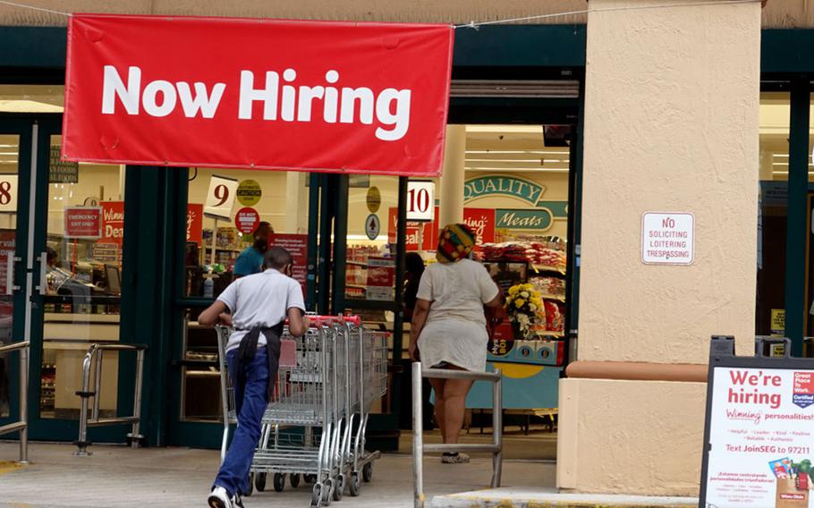 A Now Hiring sign hangs near the entrance to a Winn-Dixie Supermarket on Sept. 21, 2021, in Hallandale, Fla. 