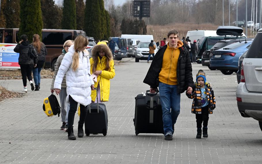 Refugees from Ukraine leave a transit site for refugees after being bused from the nearby Ukrainian-Polish border at Korczowa, Poland, Feb. 27, 2022.