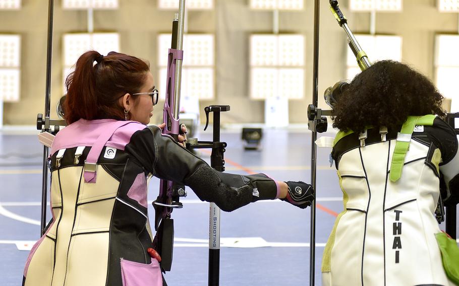 Stuttgart's Leila Ybarra, left, gestures toward teammate Nole Smith during the 2023 DODEA European marksmanship championship at Wiesbaden High School in Wiesbaden, Germany.