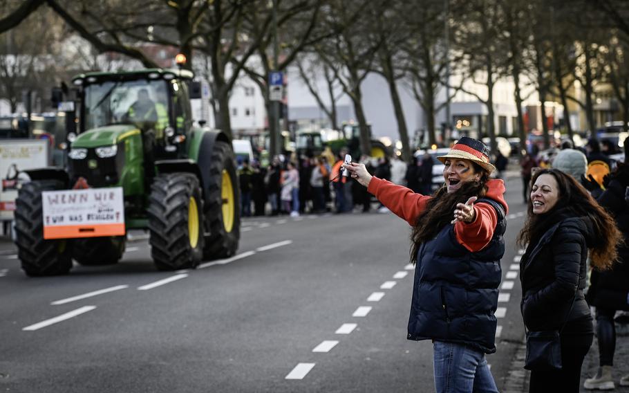 Onlookers cheer for a farm protest convoy Jan. 8, 2024, in Kaiserslautern, Germany. Farmers and truck drivers are participating in nationwide protests against government taxation and subsidy cuts.