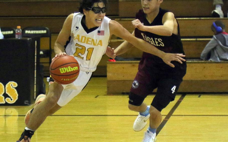 Kadena's Angel Torrado drives against American School Bangkok's Pun Oririchaivait during Monday's Far East Boys Division I Tournament pool-play game, won by the Panthers 37-28.