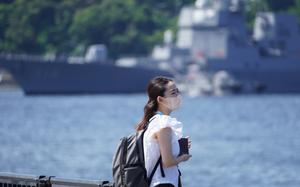A woman wears a mask during a stroll near Yokosuka Naval Base, Japan, Thursday, June 2, 2022. 