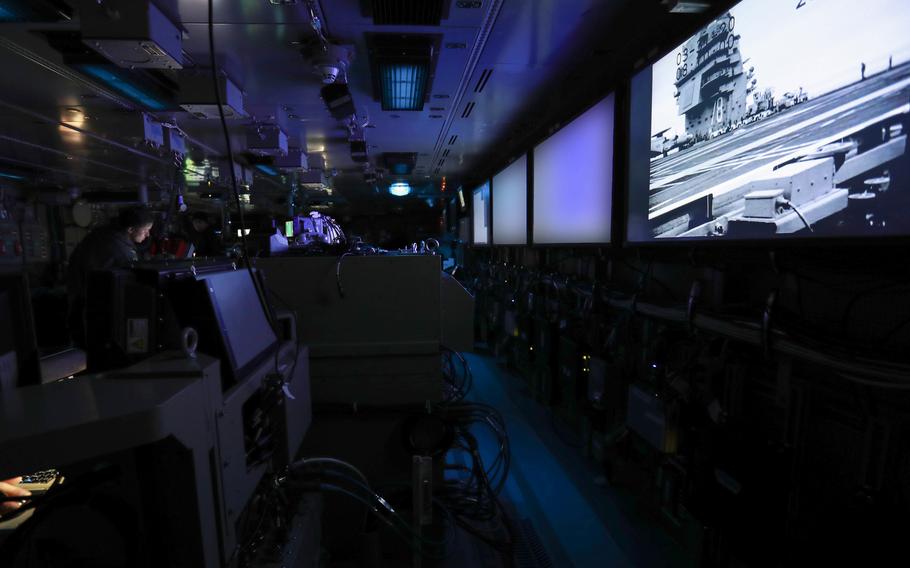 Sailors aboard the USS Gerald R. Ford stand watch in the ship's combat direction center during testing in 2020. The testing stresses the ship's combat systems, which include integration of new technologies like the dual-band radar. The screens in this photo were blurred by the Navy for security purposes.