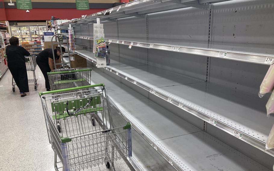 As Hurricane Ian approaches Florida, shopping carts are left abandoned next to empty shelves that stock bottled water at a supermarket Monday, Sept. 26, 2022, in Orlando, Fla. 