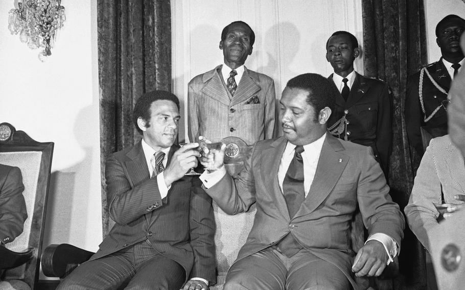 El embajador de las Naciones Unidas, Andrew Young, a la izquierda, se une al presidente vitalicio de Haití, Jean-Claude Duvalier, en un brindis después de su reunión, el lunes 15 de agosto de 1977 en Puerto Príncipe, Haití.  Young llegó con una lista de presos políticos que Carter quería liberar y otras demandas de derechos humanos.