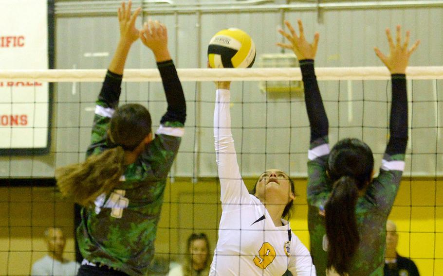 Kadena's Aylin Alvarez spikes between Kubasaki's Yuri Biggins and Runa Holladay during Tuesday's Okinawa volleyball match. The Dragons won in four sets and won the season series 3-1.