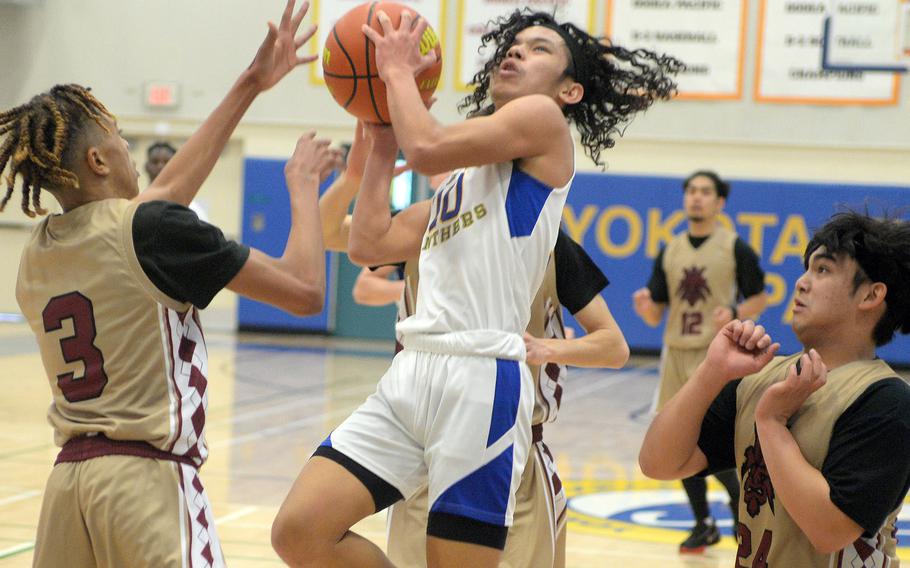 Yokota's Royce Canta drives between Matthew C. Perry defenders during Monday's Far East Boys Division II pool-play game, won by the Panthers 79-49.