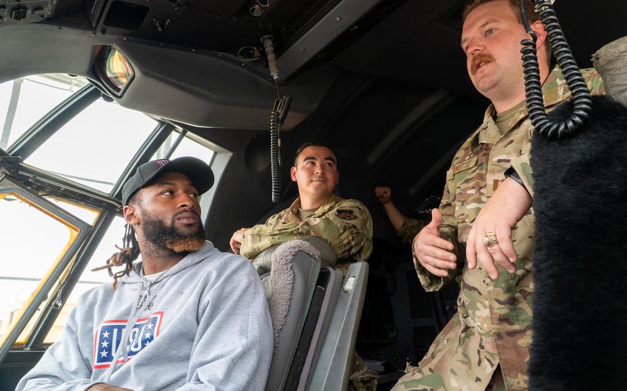 Aaron Jones sits in an aircraft and talks to an airman