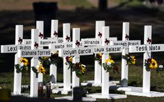 Crosses with the names of Tuesday's shooting victims are placed outside Robb Elementary School in Uvalde, Texas, Thursday, May 26, 2022. The 18-year-old man who slaughtered 19 children and two teachers in Texas left a digital trail that hinted at what was to come.  (AP Photo/Jae C. Hong)