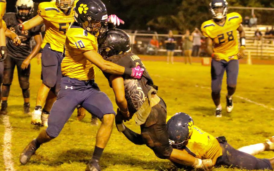 Guam High's Alex Gallego and Cameron Brantley corral Adin Lumba of Simon Sanchez.