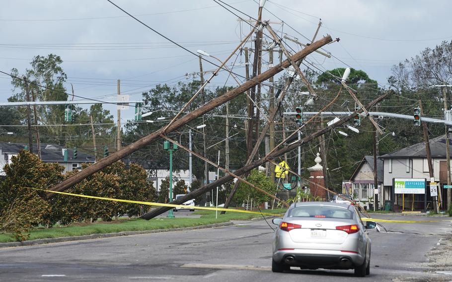 Traffic diverts around downed power lines Monday, Aug. 30, 2021, in Metairie, La. 