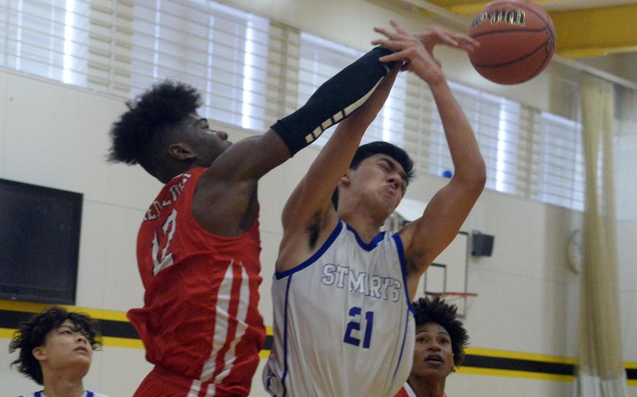 St. Mary’s Caio Shiota (21) has the ball slapped away by Kinnick’s Nicholas Whyte during Thursday’s rematch of last year’s Kanto Classic final. It was only a pool-play game this time, but the Red Devils avvenged that last-second loss to the Titans.