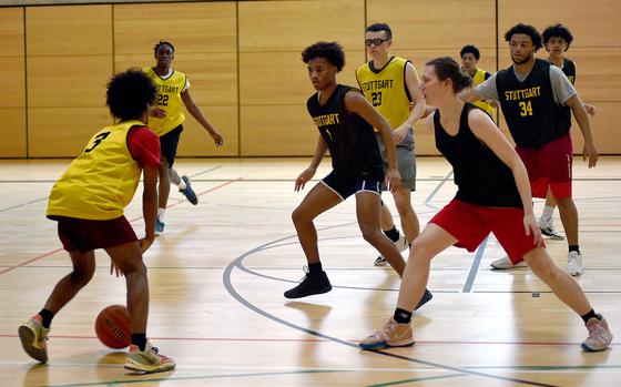 Tyler Jackson, center, and Chris Hess, right, defend Nijah Marshall, left during a Jan. 31 practice at Stutgart High School in Stuttgart, Germany. Friends since preschool, the duo reunited in 2017 when the Jackson family returned to Stuttgart, and they have been inseparable snce.
