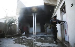 Soldiers with the U.S.-backed Syrian Democratic Forces check a house in Hassakeh, Syria, Tuesday, Jen. 25, 2022. After breaking into the prison late Thursday, IS militants were joined by others rioting inside the facility that houses over 3,000 inmates, including hundreds of minors. 