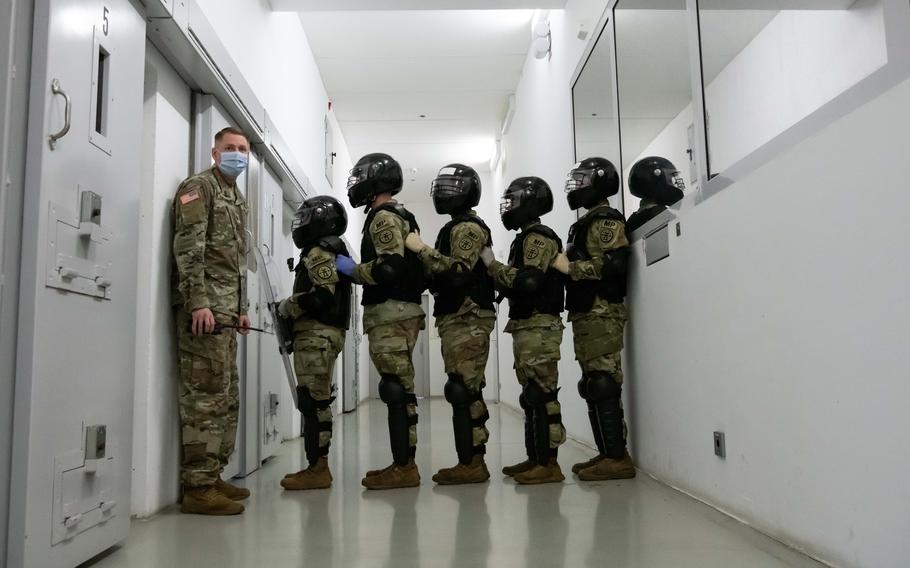 Guards at U.S. Army Regional Correctional Facility-Europe practice a maneuver used to remove noncompliant inmates from their cells Tuesday, Nov. 22, 2022.