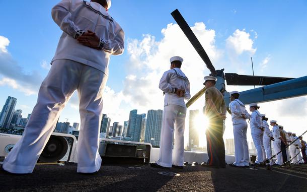 Sailors and Marines stand at parade rest on the flight deck of the USS Bataan amphibious assault ship as it pulls into the port of Miami for Fleet Week on Sunday, May 5, 2024.